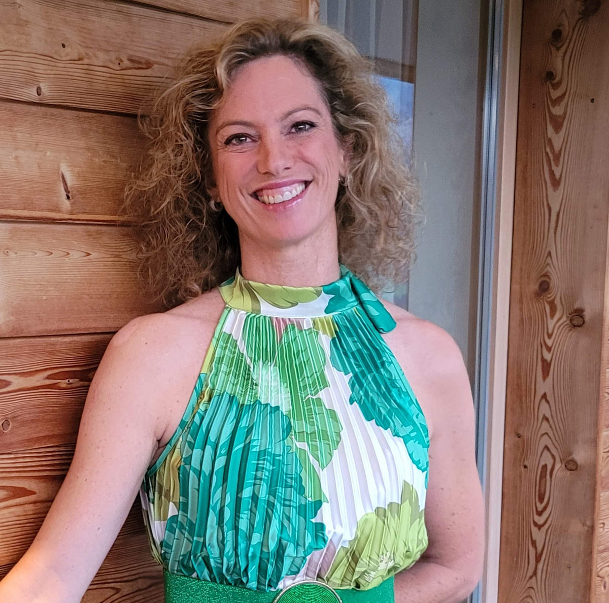 Kerstin Ottmann, QiGong-Lehrerin in München, lächelnd vor einer Holzwand