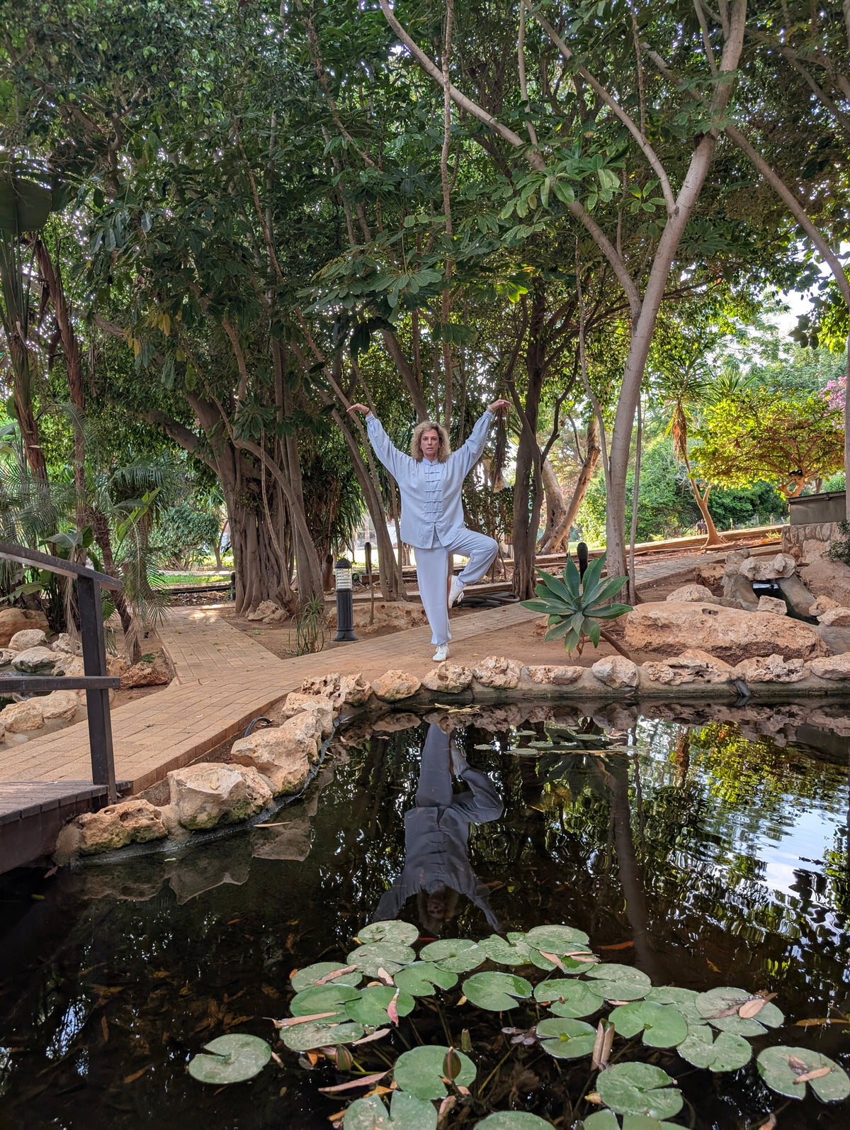 Kerstin Ottmann in einer QiGong-Haltung auf einem Bein am Seerosenteich